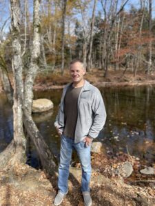 Man standing by river in the woods